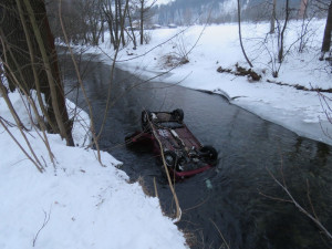 Řidička dostala na zledovatělé silnici smyk, její auto skončilo na střeše v řece