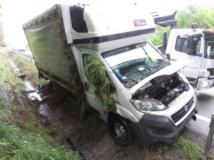 Řidič na dálnici sjel se svým náklaďákem mimo cestu, vůz skončil převrácený na boku