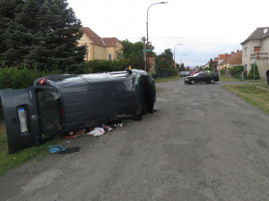 Dvě osobní auta se střetla v křižovatce, jedno z nich zůstalo po kolizi převrácené na boku