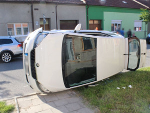 Žena bez řidičáku při couvání nabourala projíždějící auto. To skončilo na boku